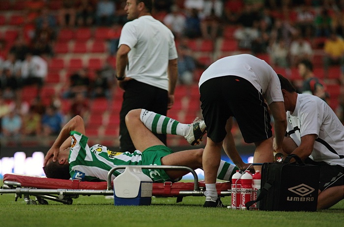 Dian opouští hřistě na nosítkách.