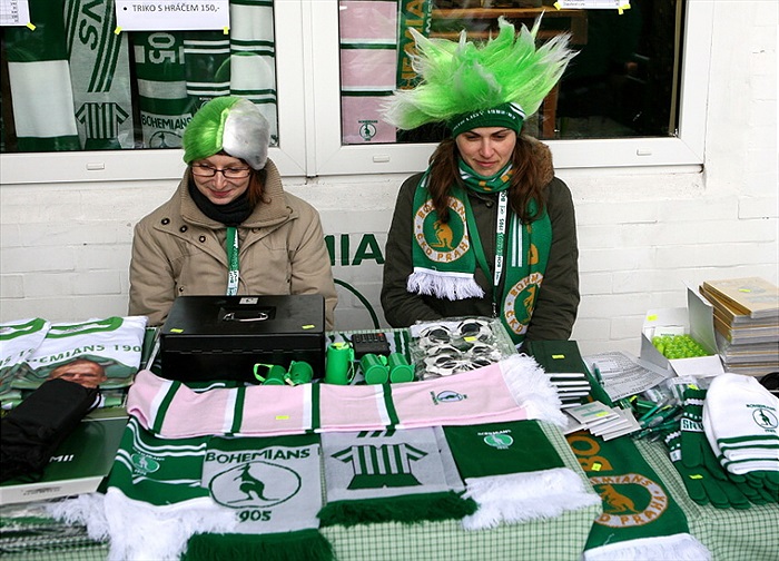 Styloví prodejci před fanshopem.