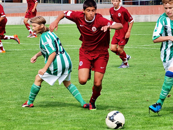 Kdo bude u míče dřív? Náš Kevin Radimský nebo Sparťan Surmaj? Adam Petřík (13) se tváří, jako když se ho to netýká.