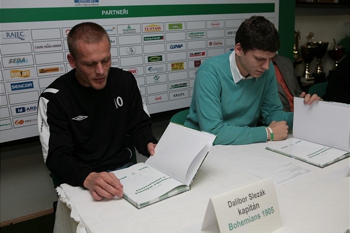 Kapitán Slezák nahlíží do knihy.